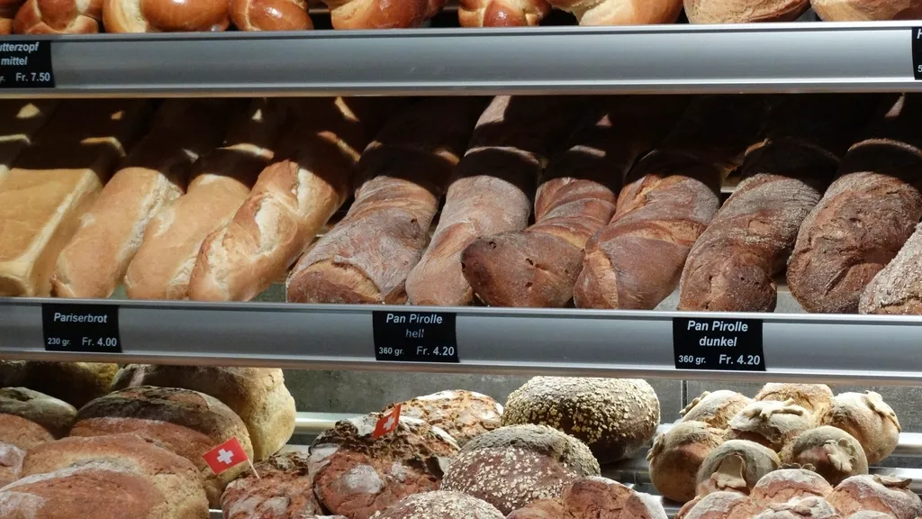 Bakery display shelves filled with loaves and bread rolls