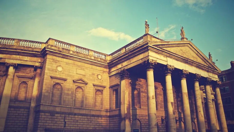 Classical stone bank building with columns at sunset