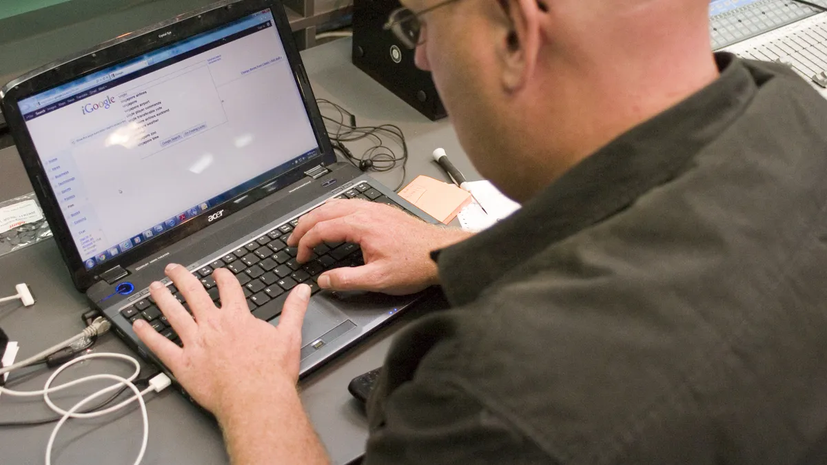 Person typing on a laptop showing a Google search page