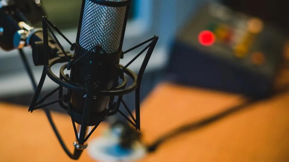 Studio microphone in a shock mount in front of audio equipment
