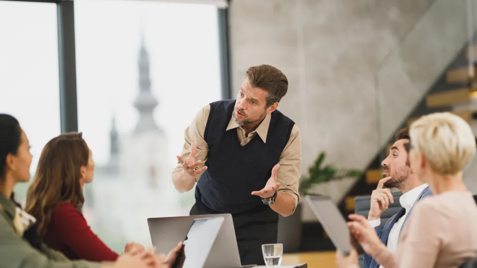 A group of people in a meeting listening to a speaker