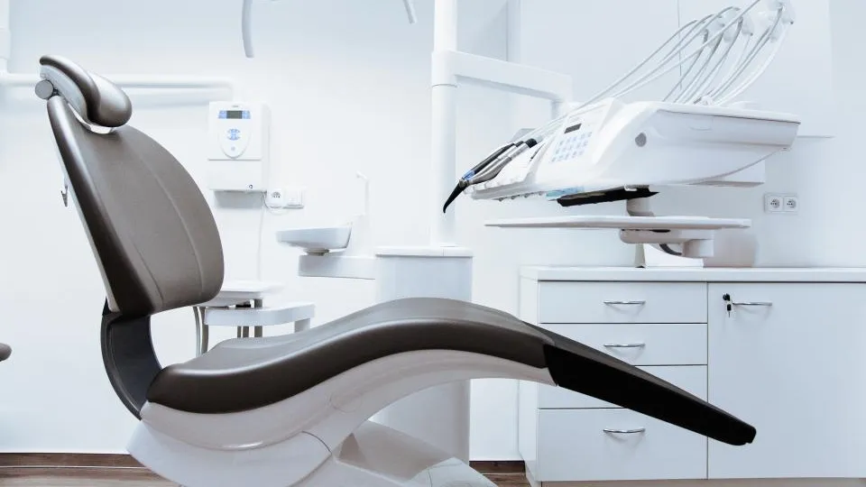 Modern dental chair and equipment in a bright clinic room