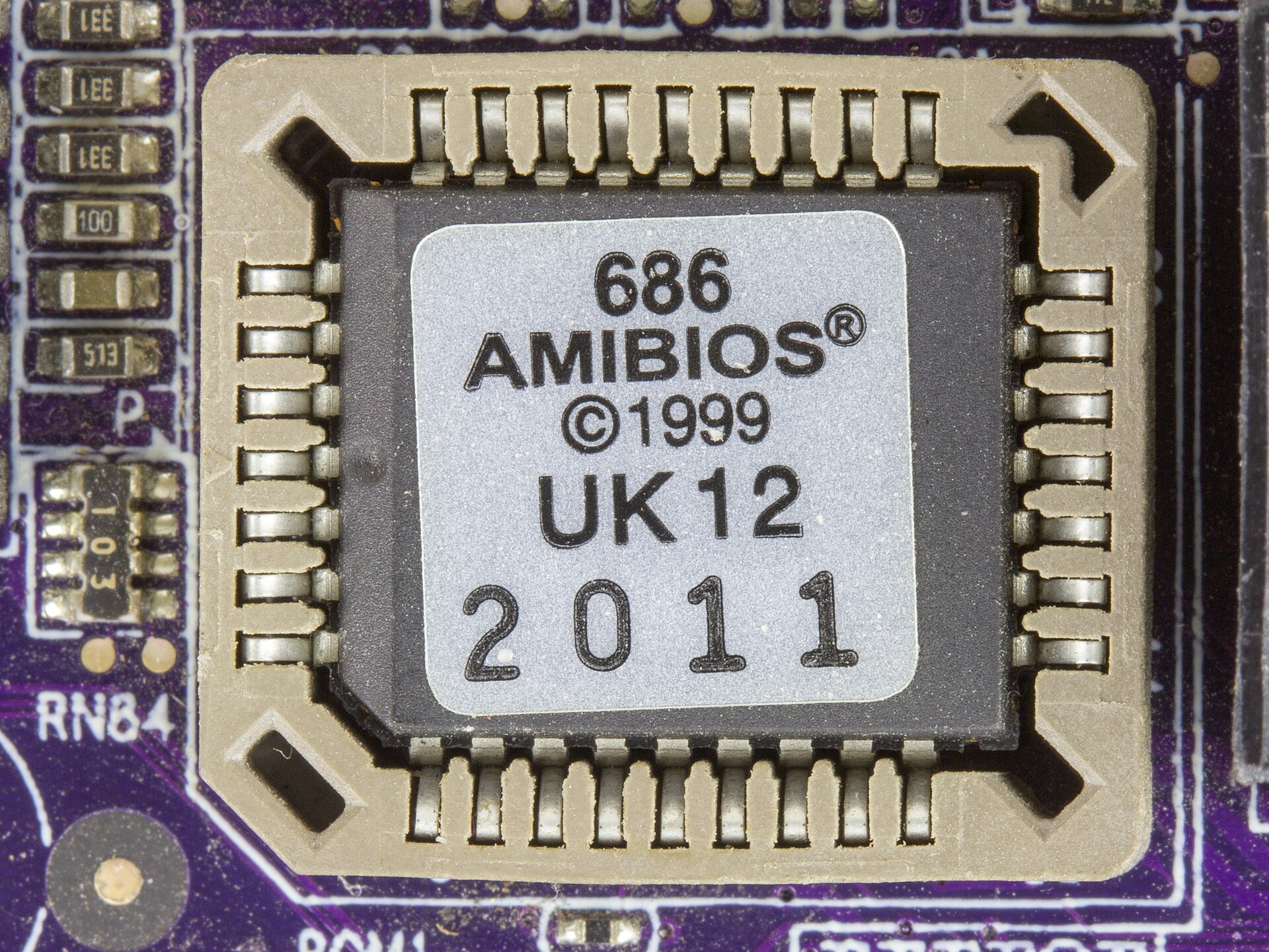 A socketed Winbond flash memory chip on a motherboard, labelled "686 AMIBIOS ©1999".