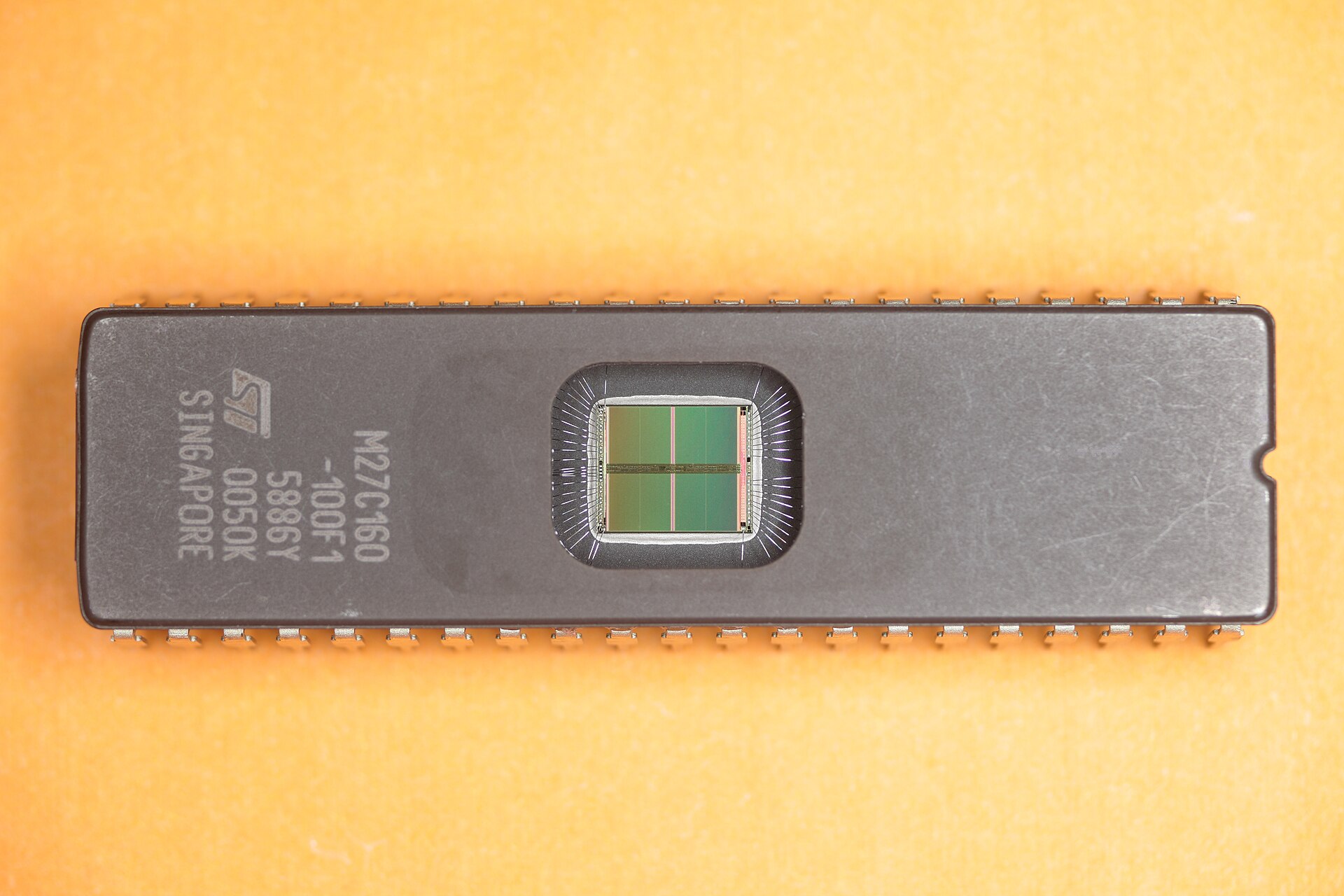 A 42-pin ST M27C160 UV-erasable EPROM chip with a clear quartz window over the silicon die.