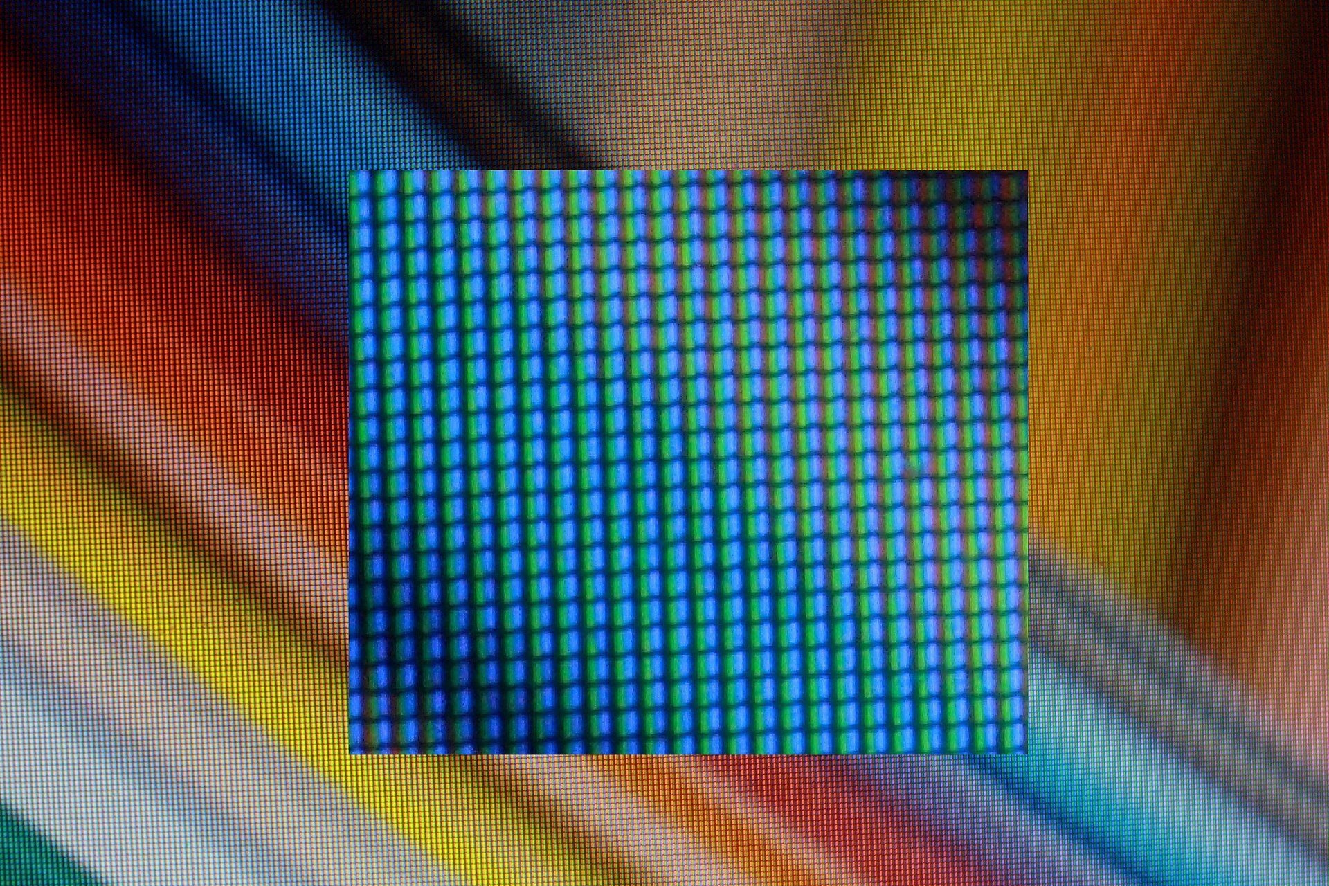 Macro photo of a laptop LCD showing rows of tiny red, green and blue subpixels, with a zoomed inset